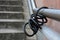 Bike lock attached to metal railing at public stairs leading to train station with bicycle missing, presumably stolen
