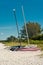 Bike and pair of sailing catamarans, on sandy beach