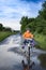 Bike in the park moving through puddle on rainy day. Boy on a bicycle at asphalt road in summer