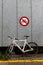 A bike is parked under a bicycle prohibited sign