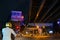 A bike rider wearing helmet is waiting in red traffic signal to be green, under Park Circus flyover at night