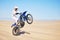 Bike, sand and motion blur with a man in the desert for adrenaline, adventure or training in nature. Energy, speed and