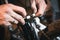 Bike service: mechanic serviceman repairman installing assembling or adjusting bicycle gear on wheel in workshop