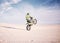 Bike, space and balance with a sports man riding a vehicle in the desert for adventure or adrenaline. Motorcycle
