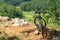 The bike stands on a hill on the edge of the cliff by the river, amid wildlife around the forest