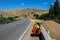 Bike to travel in the road of Iran with a valley and green grass on the side. Orange rocks and desert mountains