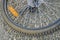 Bike wheel close-up with orange light reflector on the stone background. Bicycle detail. Flat tire