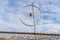 Bike wheel rim above a fence with sky background