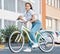 Bike, young woman and city portrait of student, gen z girl and influencer cycling in summer street for eco friendly