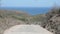 Biker biking on a dirt road to the ocean