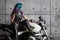 Biker chick in front of motorcycle. Beautiful and pert young woman in leather clothes