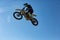 Biker does the trick and jumps in the air. Extreme concept, adrenaline. Copy space. Sky background