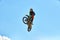 Biker does the trick and jumps in the air. Extreme concept, adrenaline. Copy space. Sky background