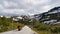 Biker drives alone on a beautiful highland, between snowy mountains in Norway during the summer