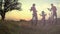 Biker family silhouette on the field at sunset