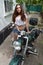Biker girl sitting on vintage custom motorcycle. Outdoor lifestyle toned portrait