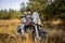 biker in medieval knight\'s armor sits on a motorcycle against the background of the forest