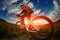 Biker in orange jersey riding on green summer field