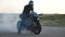 Biker performing tire burnout with lots of smoke. Motorcycle wheel are slip on route during start of movement. Wheel of