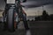 Biker sitting on black sports motorcycle on asphalt road dusk under cloudy sky. copy space