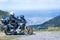Biker is sitting on his adventure motorcycle, the top mountain in background, enduro, off road, beautiful view, danger road in