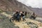 Bikers helping each other to cross the river flowing from melting snow in Himalaya mountains, Ladakh region, India