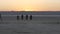 Bikers ride into sunset on lake, river, sea, bay. Motorcyclists passing desert.