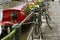 Bikes parked next to a canal and close to a boat, in Belgium. Picturesque scene. Planters with flowers and plants.