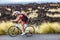 Biking triathlete man cycling road bike under the rain during triathlon race in Hawaii nature landscape. Sport athlete