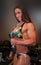 Bikini-Clad Competitive Female Bodybuilder Christy Resendes Flexes with Dumbbells