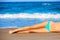 Bikini girl legs lying on beach sand in summer