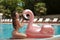 bikini girl model enjoying on inflatable lilo pink flamingo pool float mattress in fashion swimwear. Attractive tanned woman