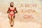 A BIKINI KINDA GIRL inspirational beach concept quote written on picture of girl sun tanning lying on sand and water in