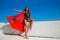 Bikini model with long hair. Beautiful girl with red scarf on the beach over blue sky.  Fashion sexy brunette model woman with