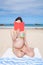 Bikini pregnant reading book at beach