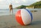 Bikini woman standing colorful beachball beach