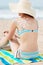 Bikini Woman In Sunhat With Sun Drawn On Back At Beach