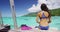 Bikini woman on tropical travel sitting on overwater bungalow of luxury resort