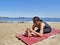 Bikram yoga paschimottanasana pose at beach