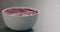 Bilberry yogurt in white bowl on concrete surface