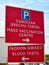 Bilingual English and Welsh sign for mass vaccination centre and blood tests