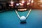 Billiard ball with two sticks on blue table