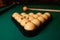 Billiard cues and pyramid of yellow pool balls on green billiard table