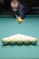 Billiard player arm breaking the pyramid by striking the ball with cue stick