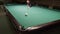 Billiard player makes a beautiful shot and scores the ball in the pocket