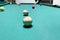 Billiard table with balls in a bar, a man with a cue is going to make a shot in the game of pool in a tournament
