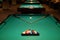 Billiard tables with balls and cues in club