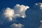 BILLOWING DARK CLOUD WITH PUFFY WHITE CLOUDS IN A BLUE SKY