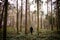 Binary portrait of a young woman aged 20-24 in winter clothes  coat and knitted hat walking through the autumn forest in the