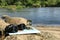 Binoculars, compass and map on stone near river. Camping equipment